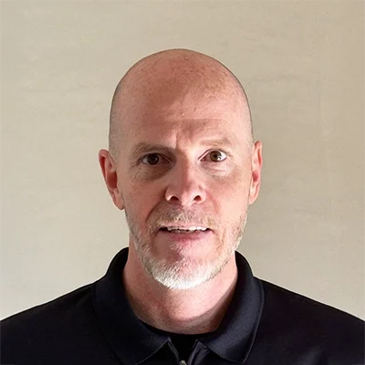 Chris Manning smiling in a black shirt.